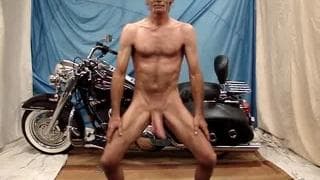 Szczupły gej wali kutasa obok motoru