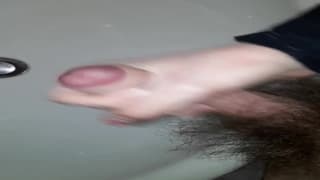 Młody zarośnięty facet spuszcza się do zlewu