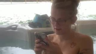 Cycata blondynka kąpie się w jacuzzi na dworze